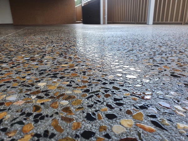 A close view of a polished concrete floor with tan and black stone showing through