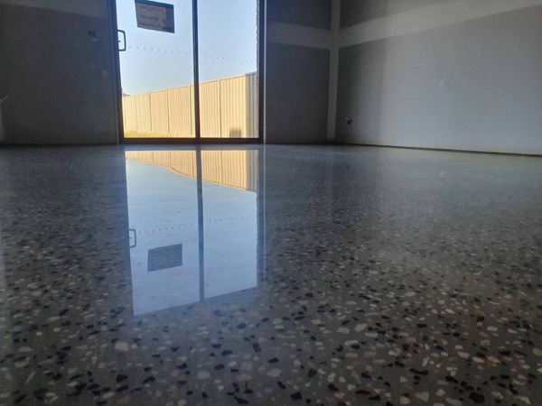A polished concrete floor with exposed stone in an empty room